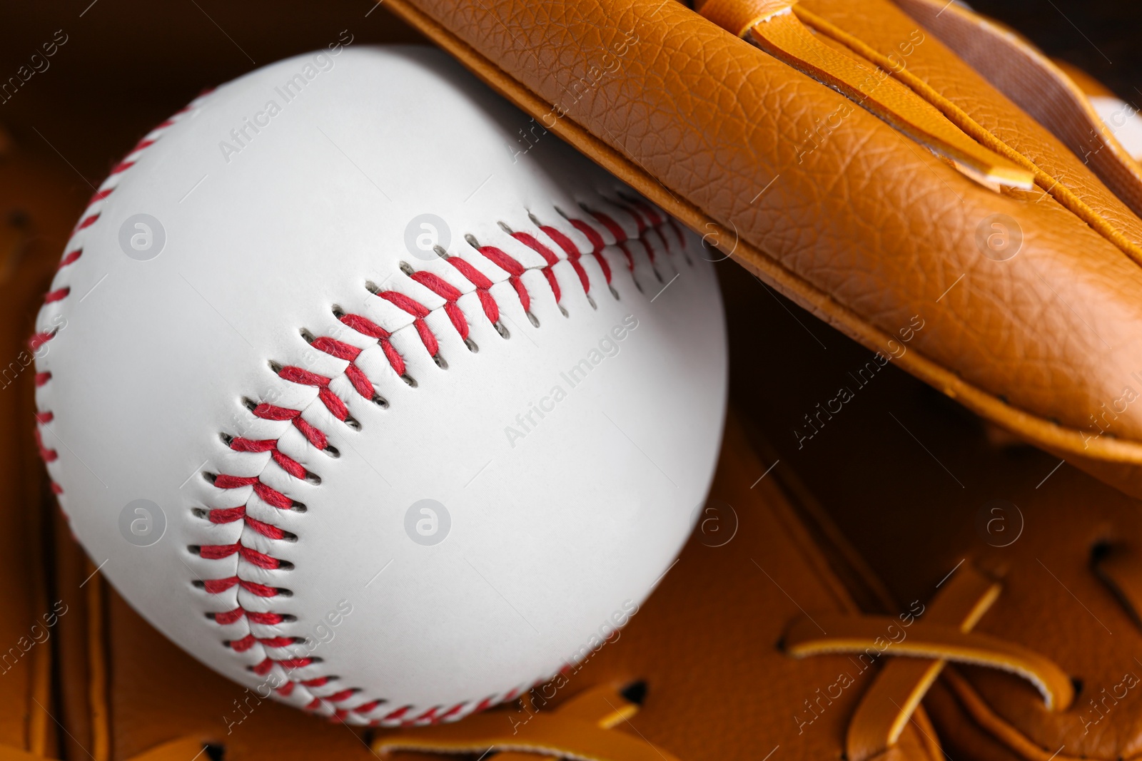 Photo of Leather baseball glove with ball, closeup. Sportive equipment