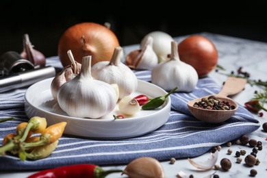 Composition with onion, garlic and pepper on kitchen table