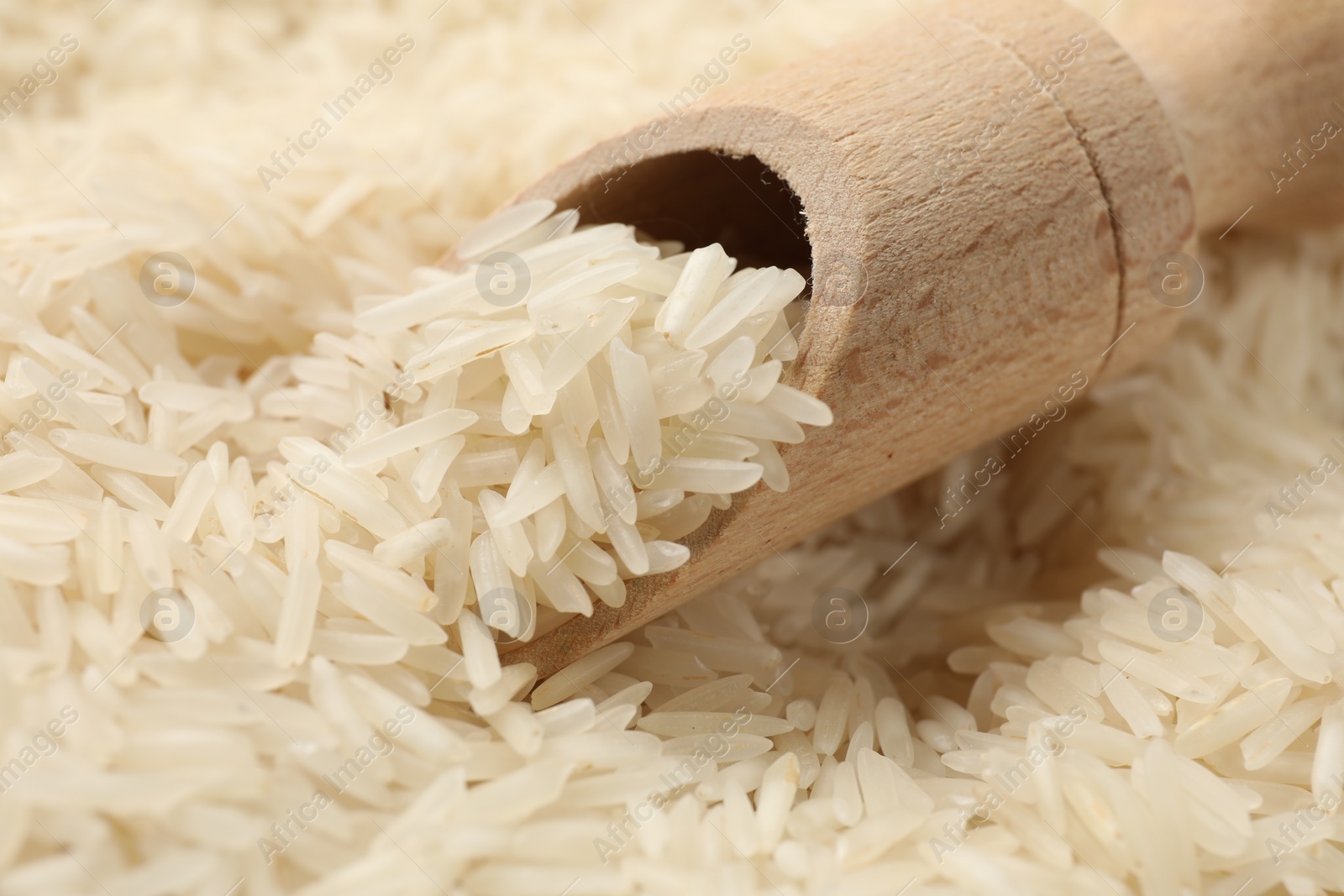 Photo of Raw basmati rice and wooden scoop, closeup