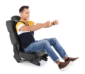 Young man sitting in car seat with safety belt on white background