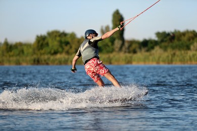 Teenage boy wakeboarding on river. Extreme water sport