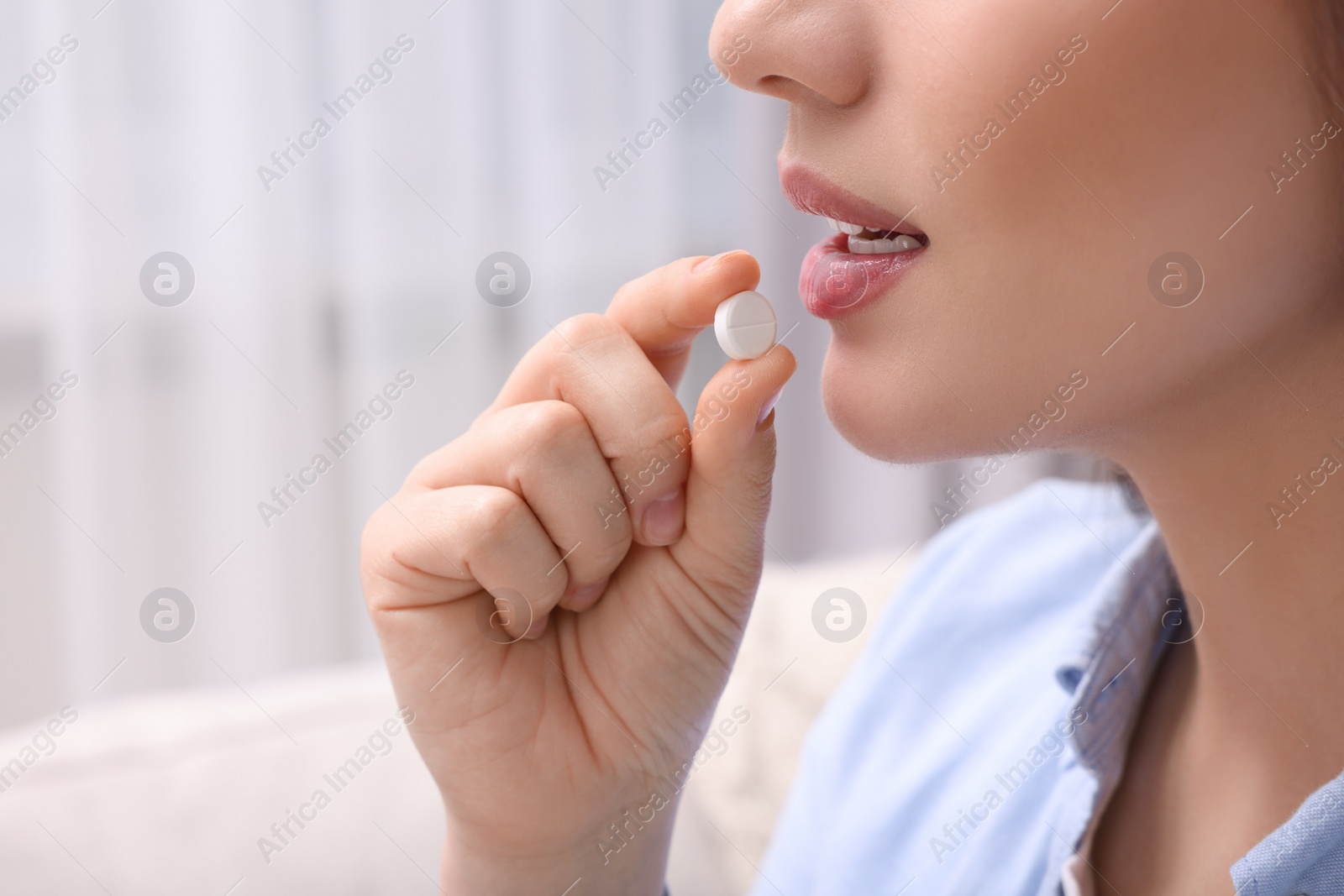 Photo of Woman taking pill at home, closeup view