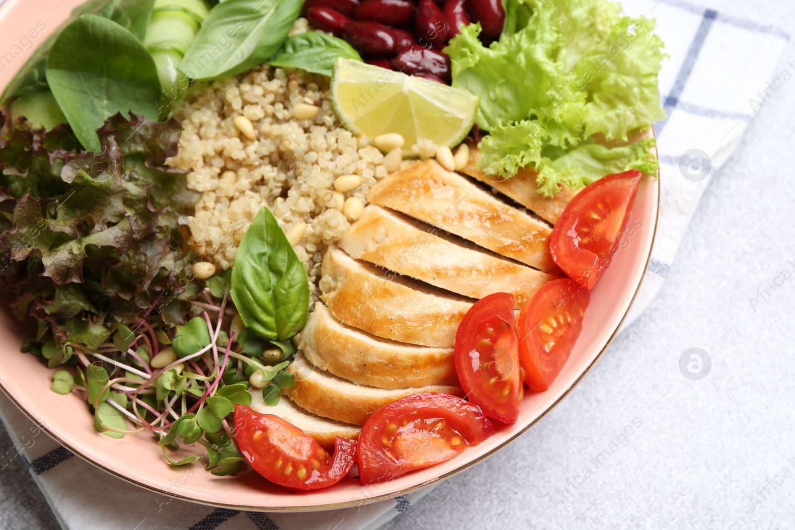 Photo of Healthy meal. Tasty vegetables, quinoa and chicken breast in bowl on white table, closeup