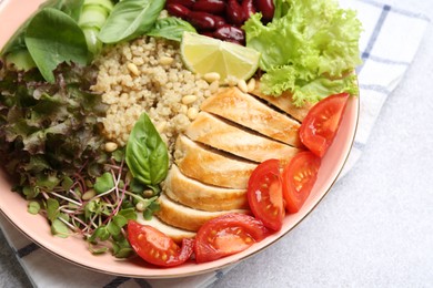 Healthy meal. Tasty vegetables, quinoa and chicken breast in bowl on white table, closeup