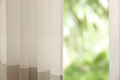 Photo of Window with elegant curtains indoors, closeup view