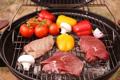 Photo of Modern grill with meat and vegetables outdoors, closeup