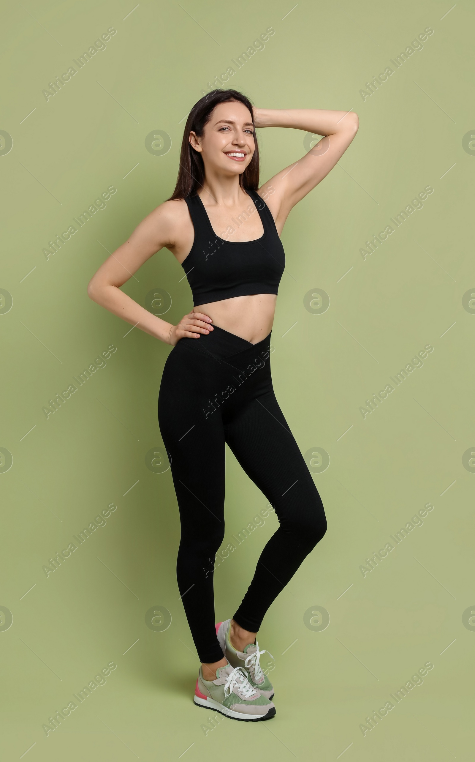 Photo of Happy young woman with slim body posing on green background