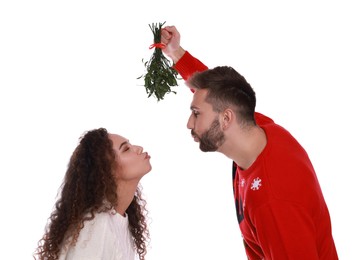 Photo of Lovely couple under mistletoe bunch on white background