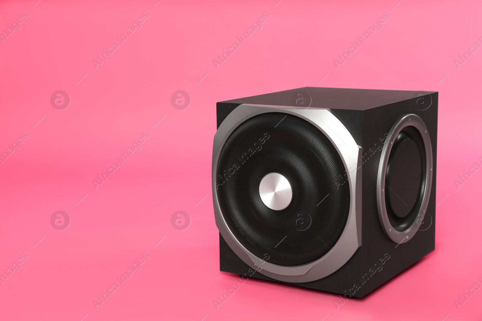 Photo of Modern subwoofer on pink background, space for text. Powerful audio speaker
