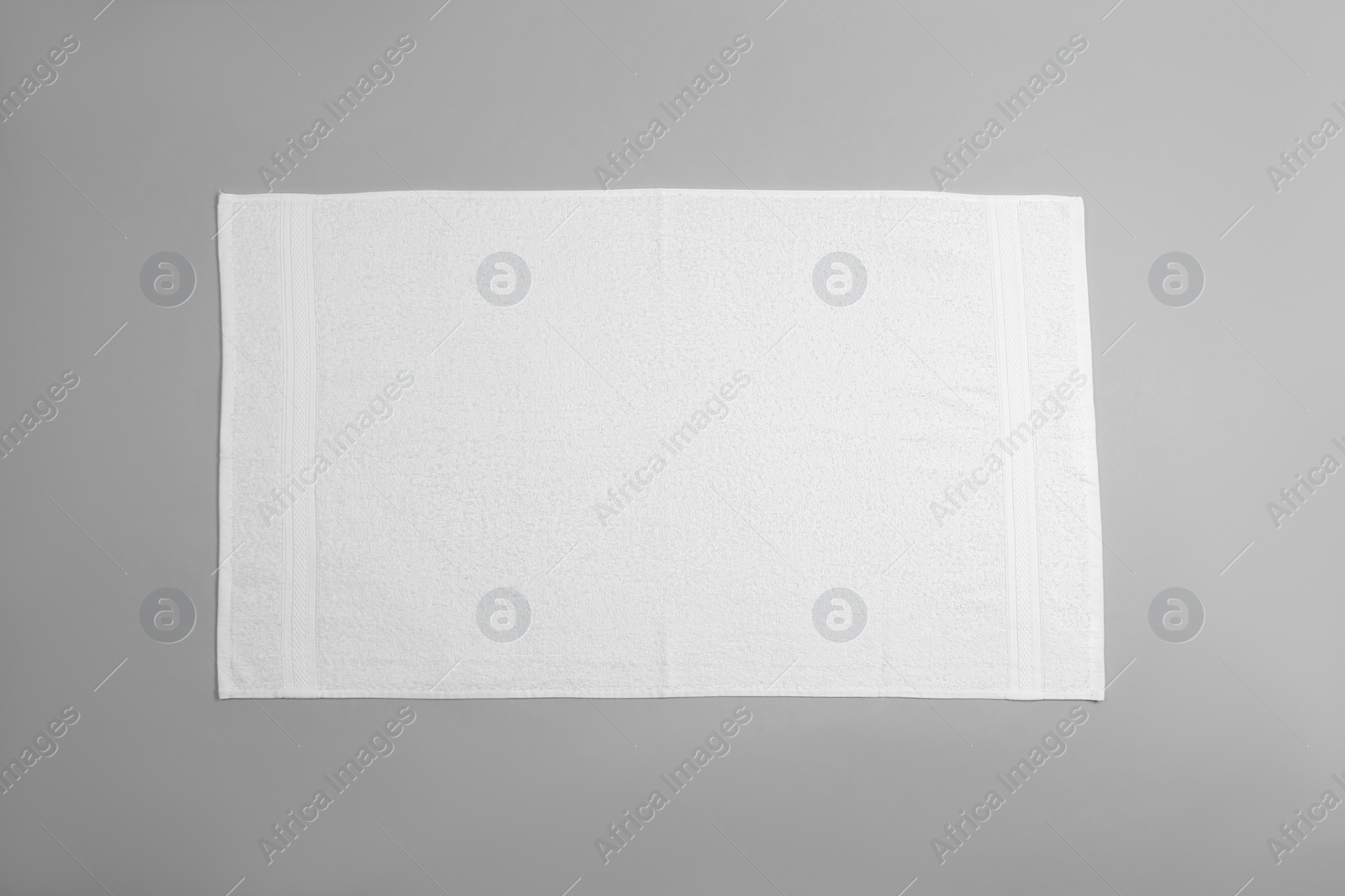 Photo of White beach towel on light grey background, top view