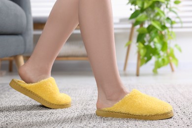 Woman in yellow soft slippers at home, closeup