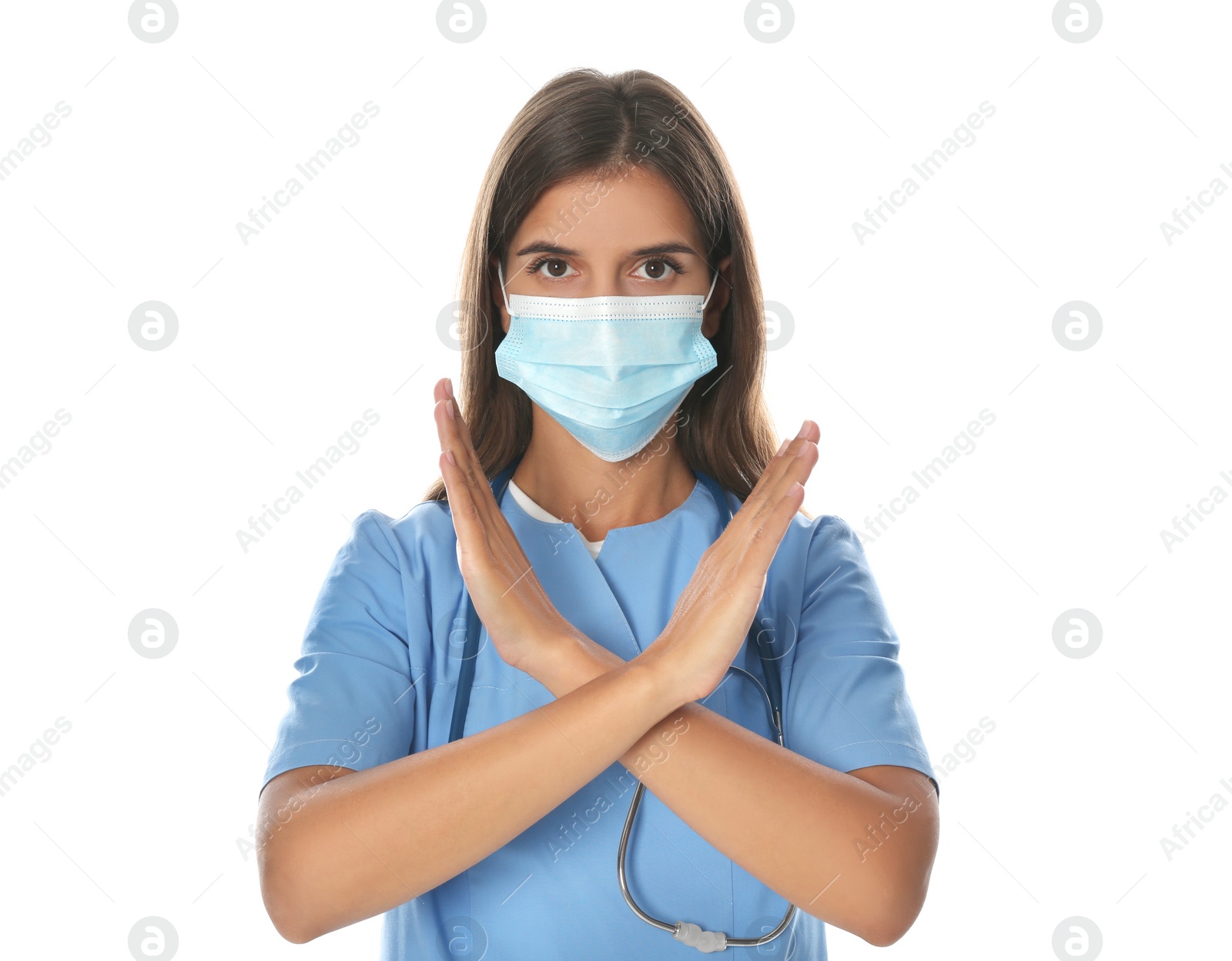 Photo of Doctor in protective mask showing stop gesture on white background. Prevent spreading of coronavirus