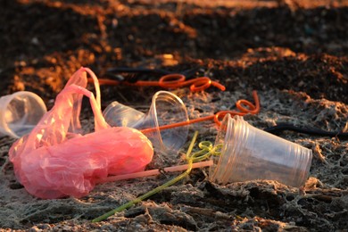 Photo of Plastic garbage at beach, closeup. Environmental pollution concept