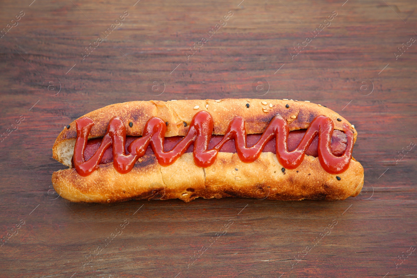 Photo of Fresh tasty hot dog with ketchup on wooden table