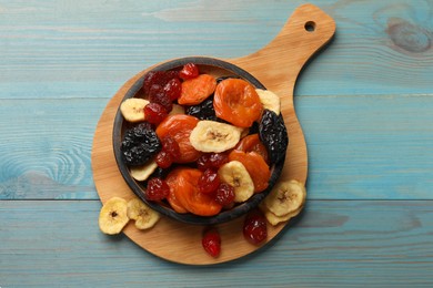 Photo of Mix of delicious dried fruits on light blue wooden table