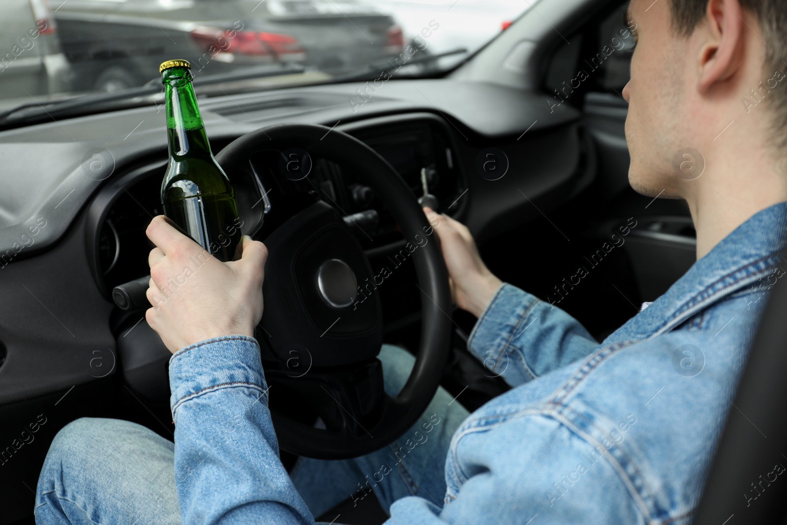 Photo of Man with bottle of beer driving car, closeup. Don't drink and drive concept