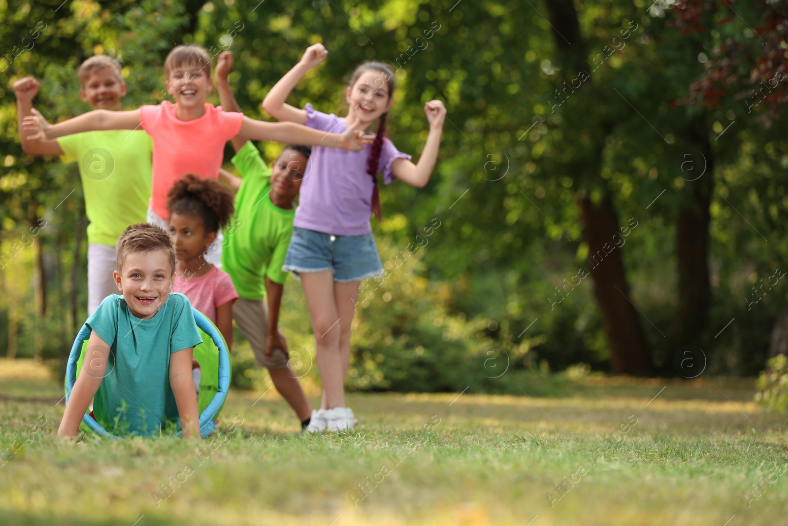 Photo of Cute little child playing with friends in park, space for text