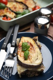 Photo of Plate of delicious eggplant lasagna and cutlery on table