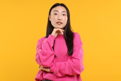 Photo of Portrait of beautiful woman on orange background