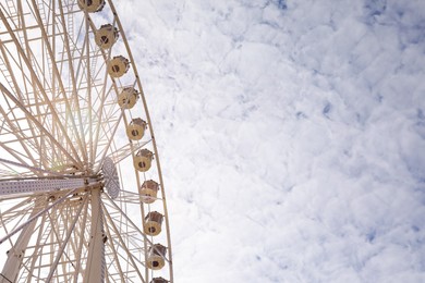 Photo of Beautiful Ferris wheel against cloudy sky, low angle view. Space for text