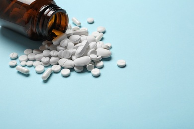 Photo of Bottle with vitamin pills on color background, space for text