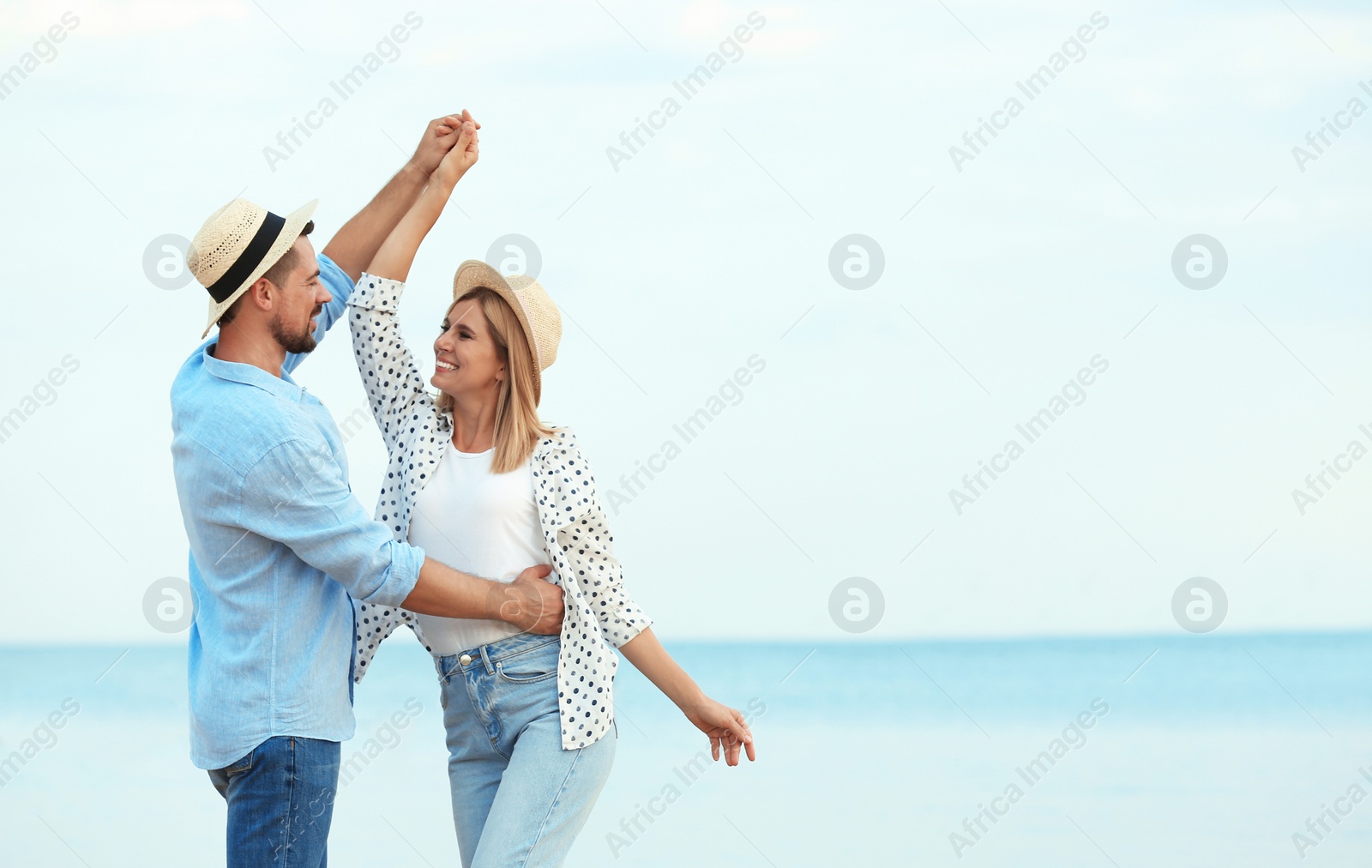 Photo of Happy romantic couple dancing on beach, space for text