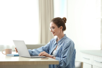 Image of Young woman working on laptop at home