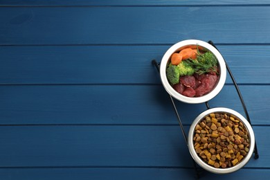 Pet food and natural ingredients on blue wooden table, top view. Space for text