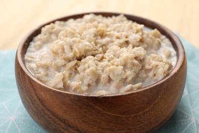 Photo of Tasty boiled oatmeal in bowl on table, closeup