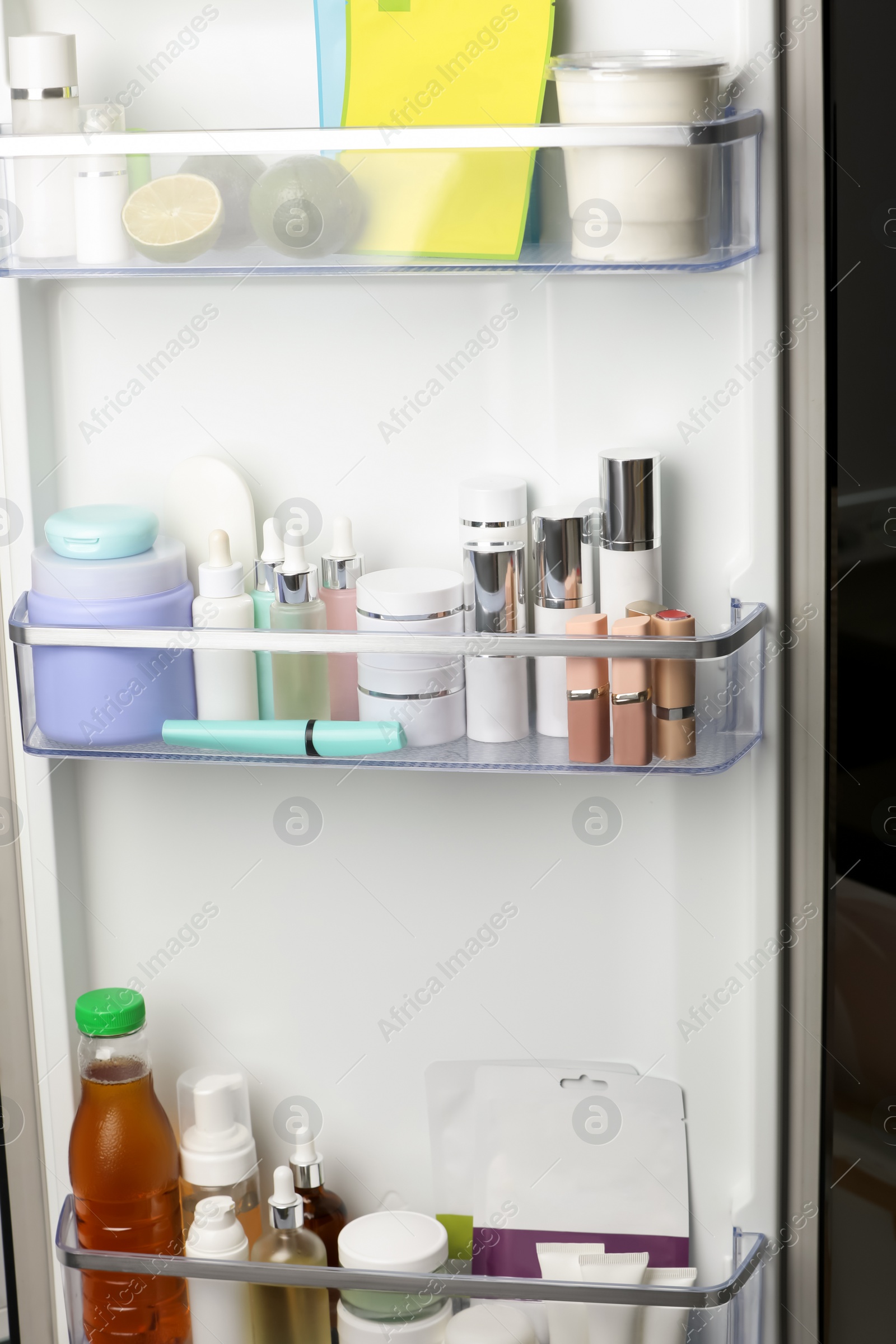 Photo of Different cosmetic products on shelves in refrigerator