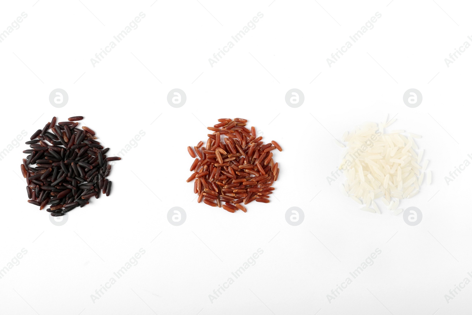 Photo of Different types of uncooked rice on white background, top view