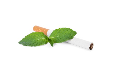 Photo of Menthol cigarette and fresh mint leaves on white background