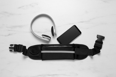 Photo of Flat lay composition with black waist bag on white marble table