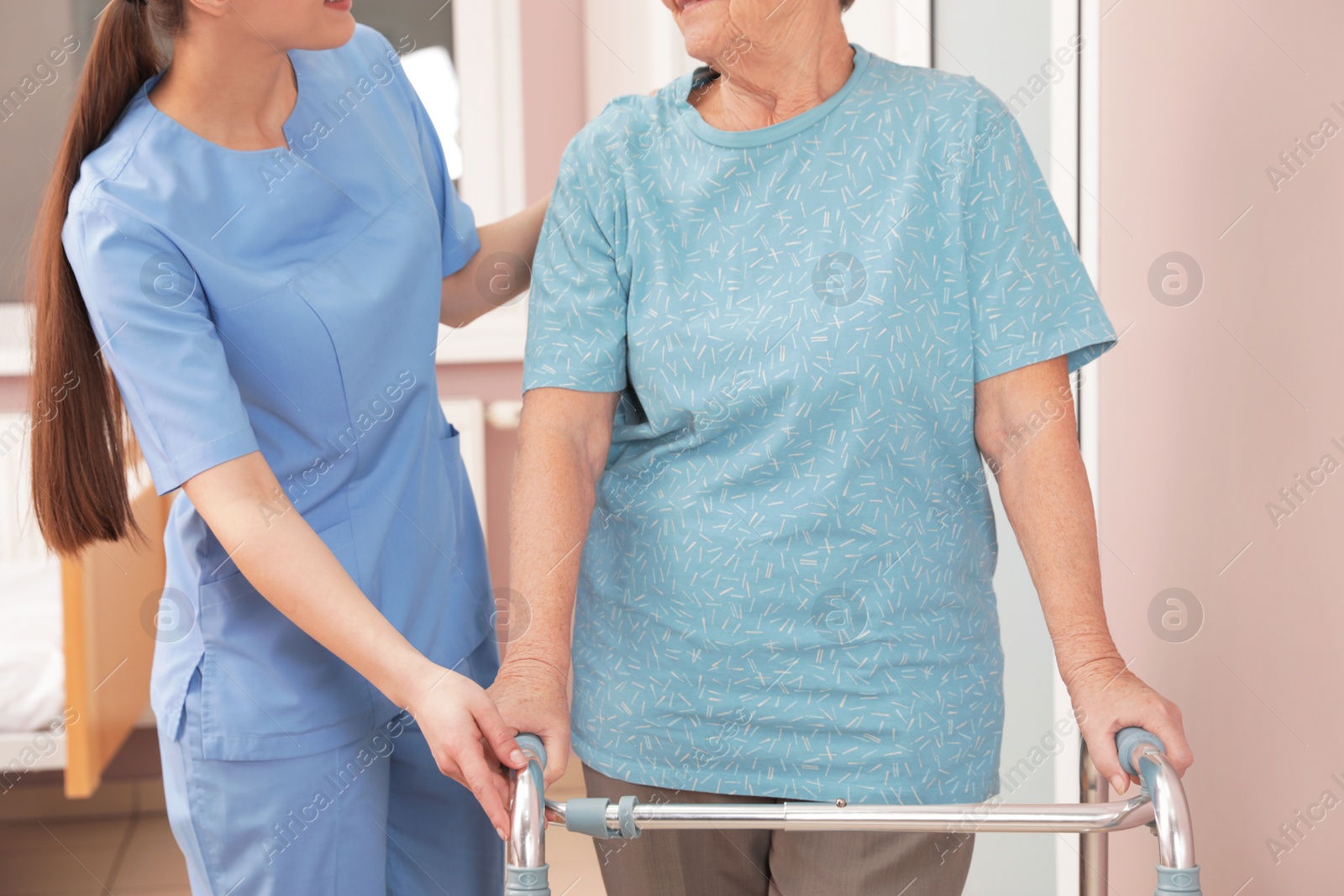 Photo of Nurse assisting senior patient with walker in hospital, closeup