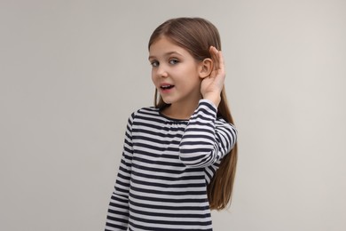 Photo of Little girl with hearing problem on grey background