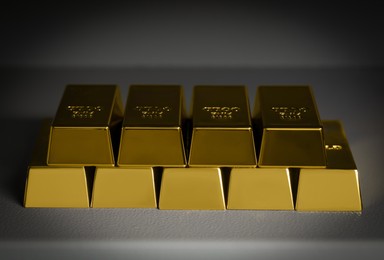 Photo of Many gold bars on light grey textured table