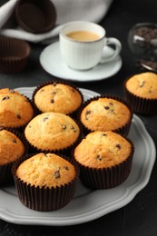 Photo of Delicious freshly baked muffins with chocolate chips on table, closeup