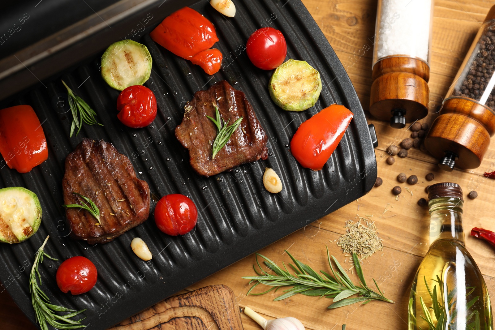 Photo of Flat lay composition with electric grill and different products on wooden table