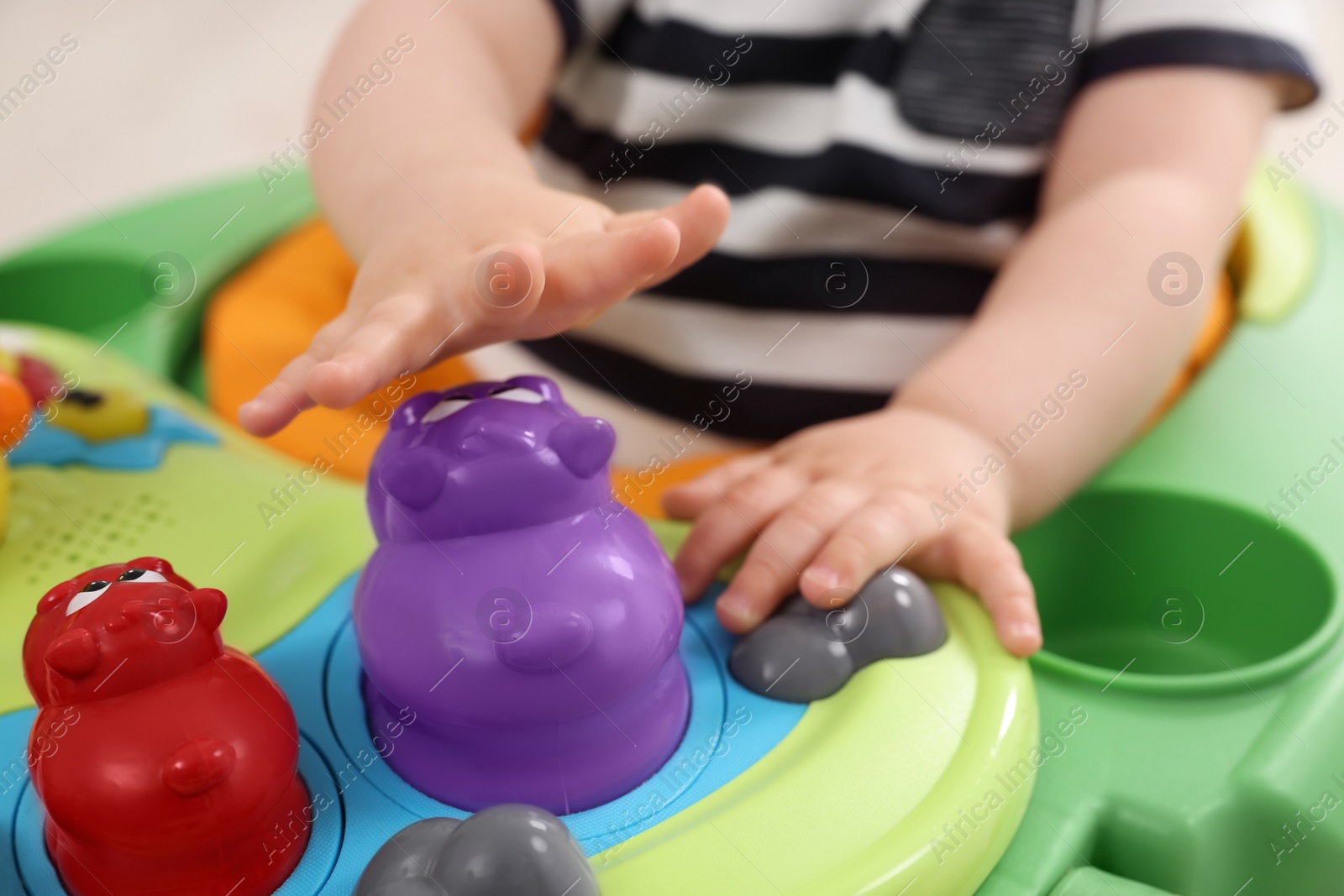 Photo of Little baby playing with toy walker, closeup