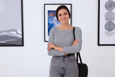 Happy young woman at exhibition in art gallery