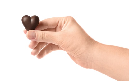 Photo of Woman holding heart shaped chocolate candy on white background, closeup