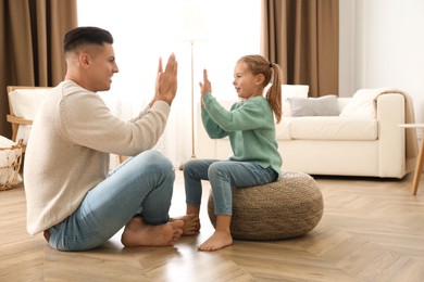 Photo of Father and his daughter having fun at home. Floor heating concept