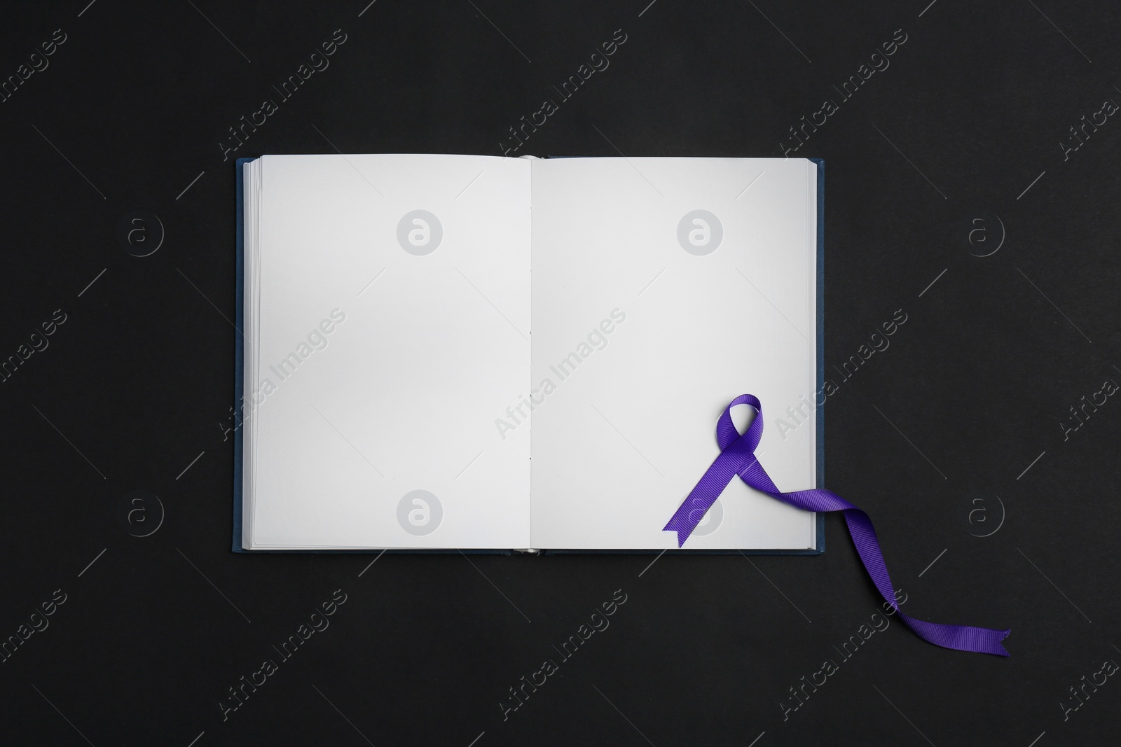 Photo of Purple awareness ribbon and open notebook on black background, top view with space for text