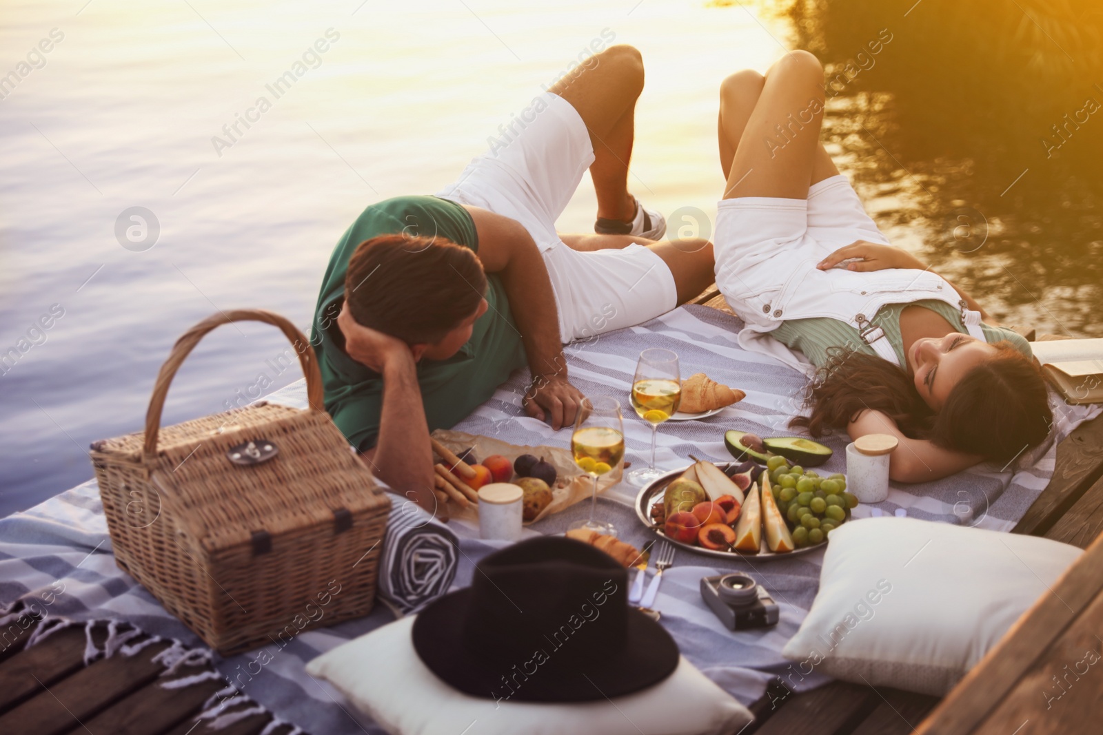 Photo of Happy couple spending time on pier at picnic