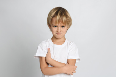 Portrait of cute little boy on light grey background