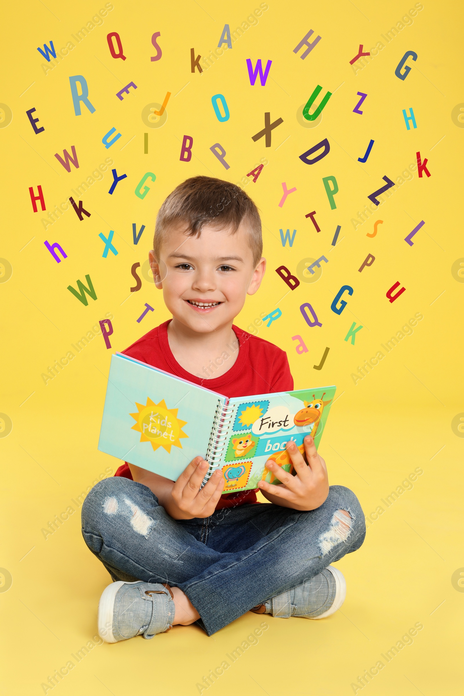 Image of Cute little boy reading book surrounded by different letters on yellow background