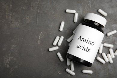 Photo of Amino acid pills on grey table, flat lay. Space for text