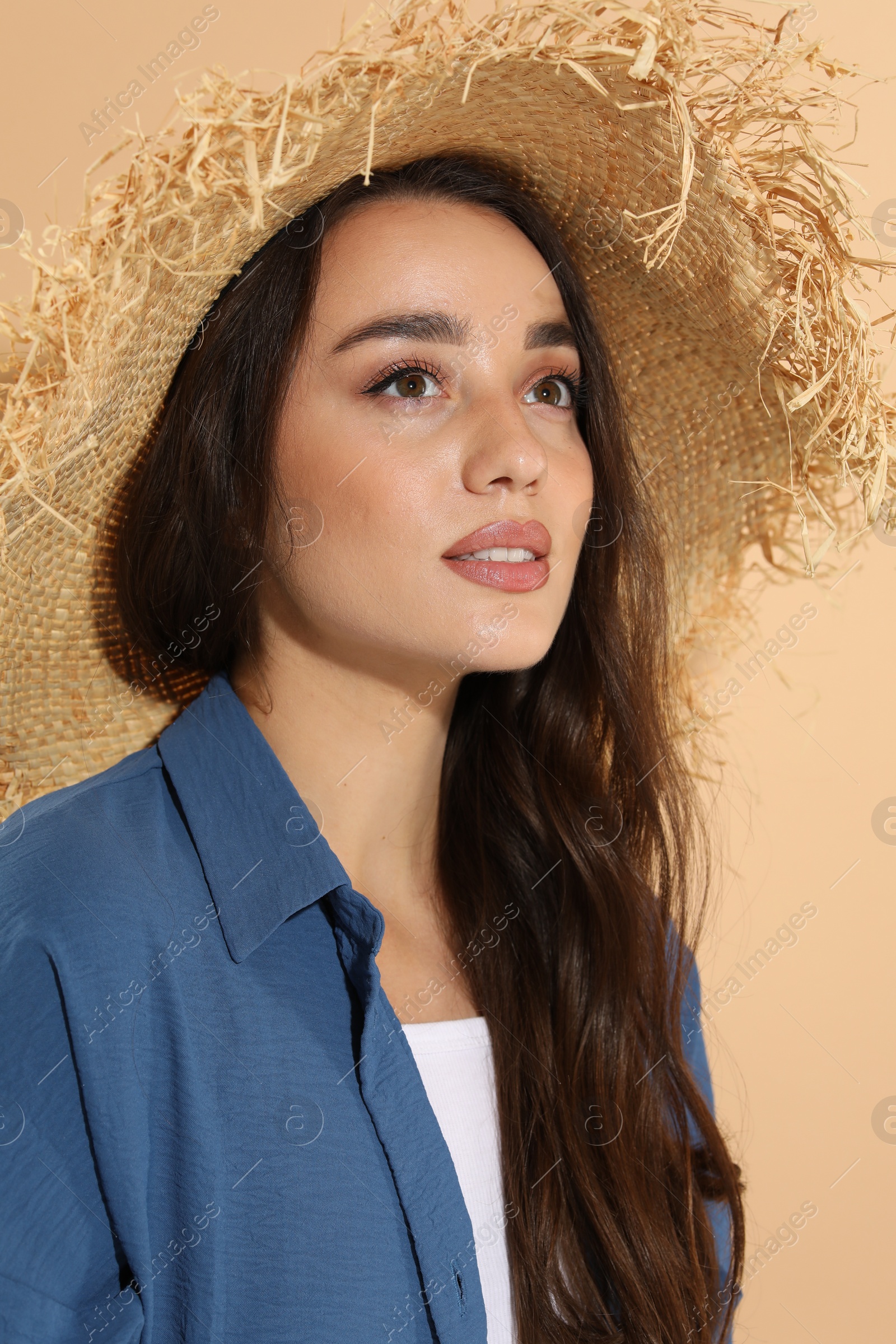 Photo of Young woman in straw hat on beige background