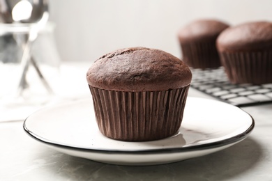 Photo of Delicious chocolate cupcake on light grey marble table, closeup