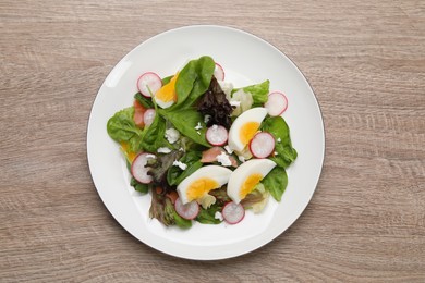 Photo of Delicious salad with boiled egg, radish and cheese on wooden table, top view